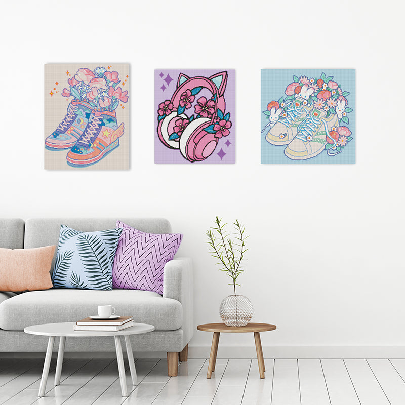 Drei Diamond Paintings an der Wand mit Kopfhörern und bunten Schuhen
